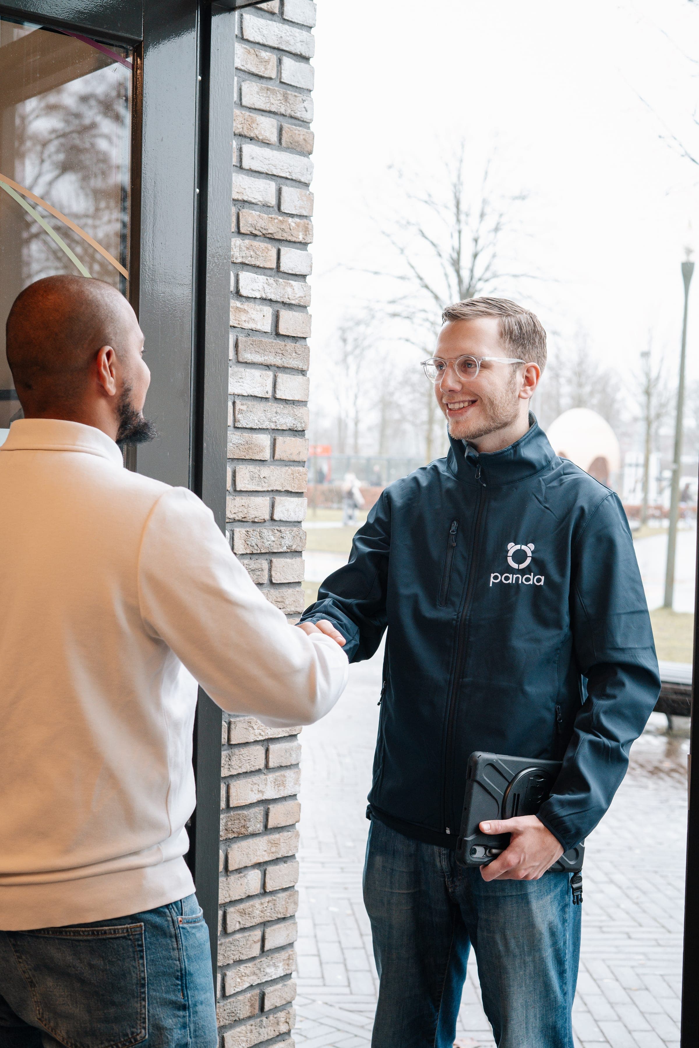 Panda-adviseur en klant ontmoeten elkaar bij ingang voor kennismakingsgesprek