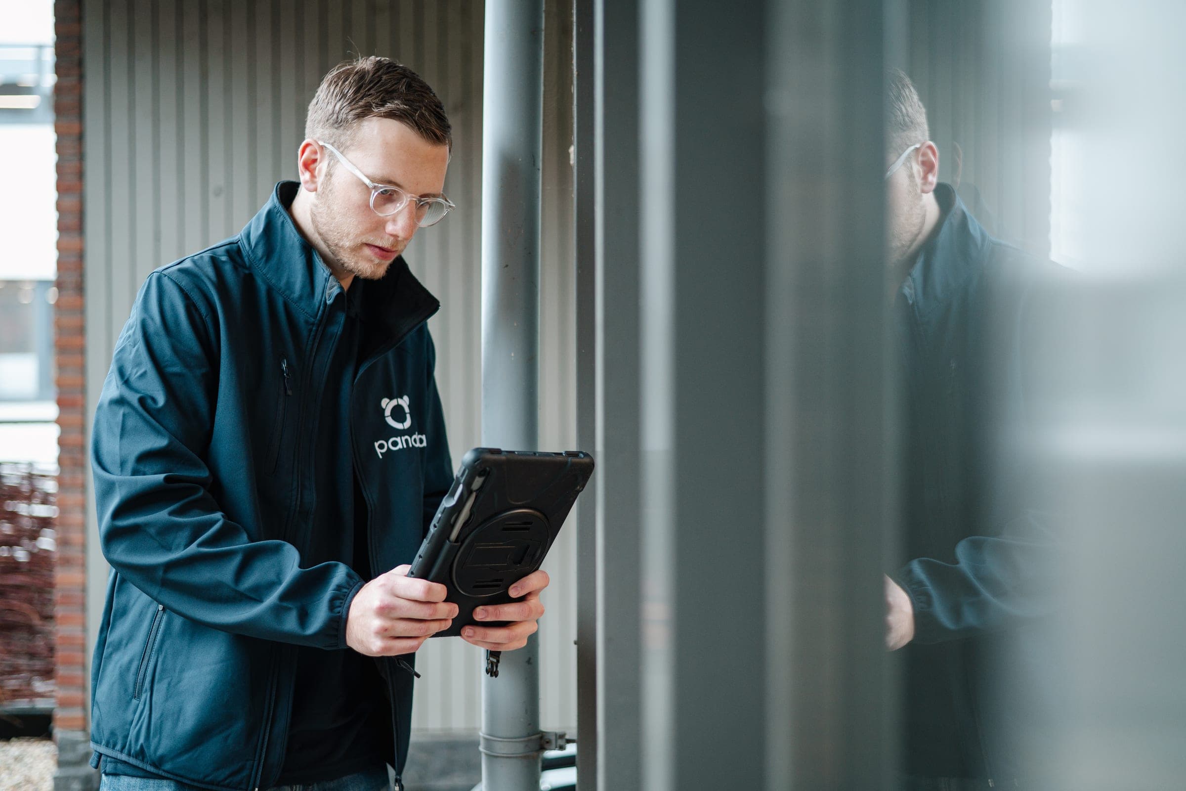 Panda-adviseur op locatie met tablet bij een installatie — drempel-toets en GACS-quickscan voor kantoren vanaf 290 kW