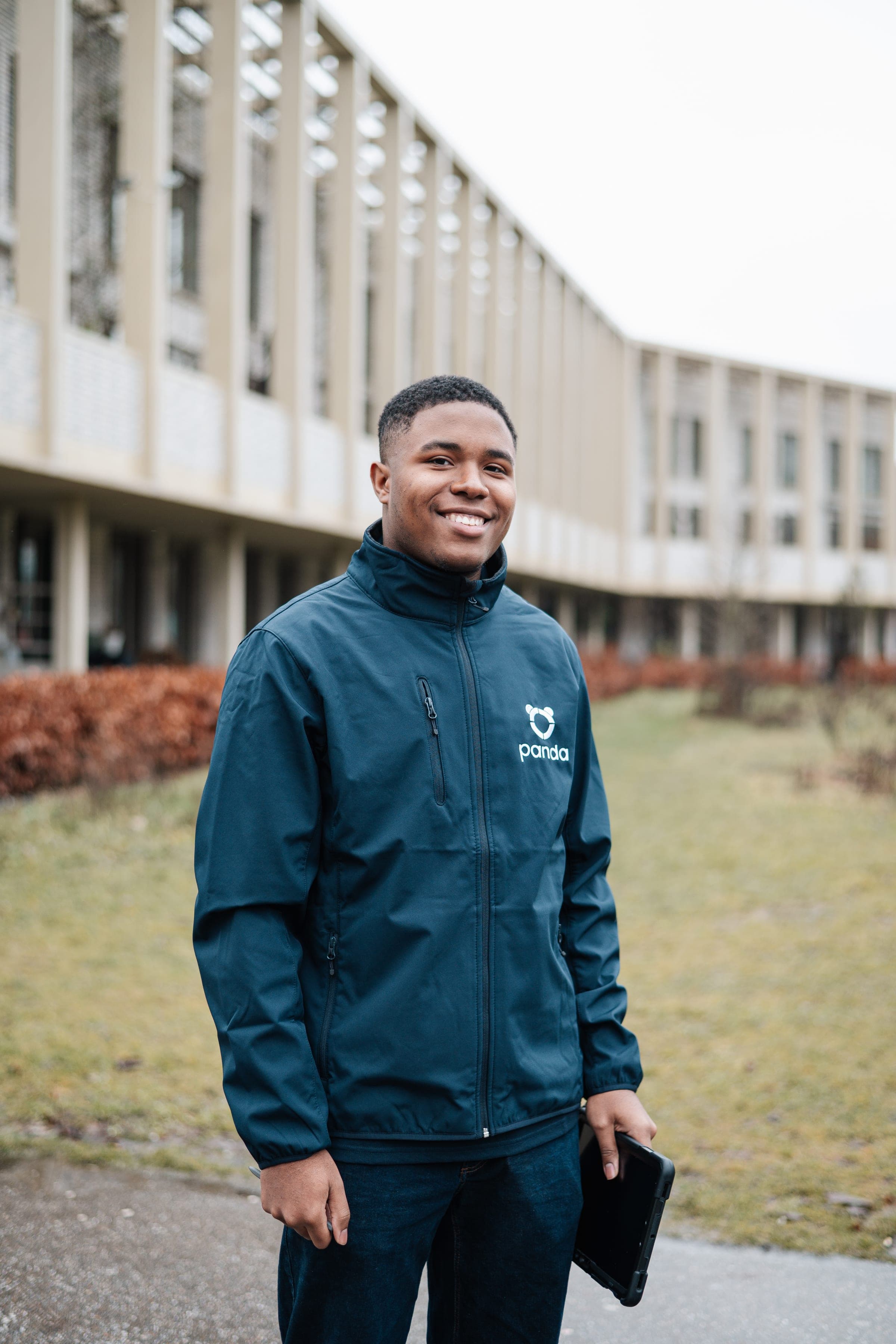 Glimlachend portret van een Panda-adviseur bij een modern gebouw